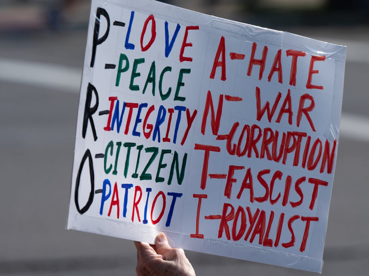 A protest sign emphasizing pro-love, peace, and integrity, against hate and war.
