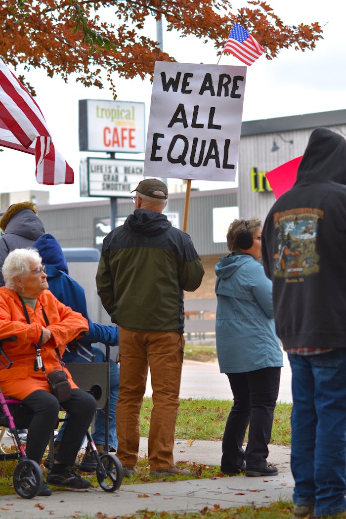 A diverse group holds signs advocating equal rights during a protest in South Dakota.